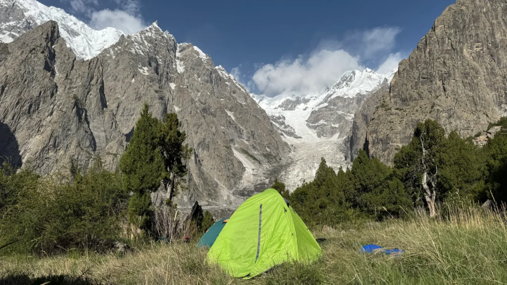 Alpine meadows camping Pakistan with tents at Fairy Meadows base camp facing Nanga Parbat glacier and peaks