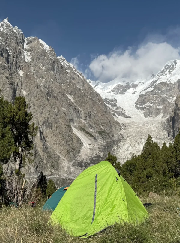 Alpine meadows camping Pakistan with tents at Fairy Meadows base camp facing Nanga Parbat glacier and peaks
