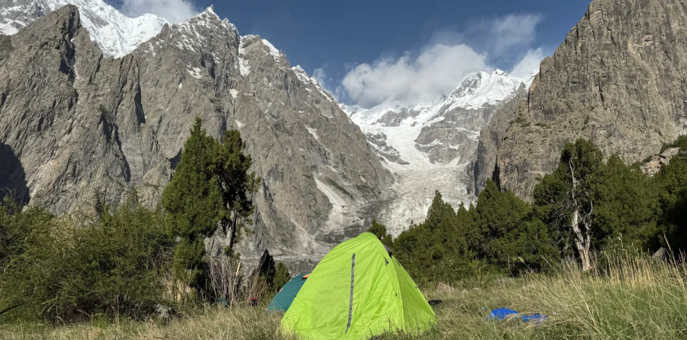 Alpine meadows camping Pakistan with tents at Fairy Meadows base camp facing Nanga Parbat glacier and peaks